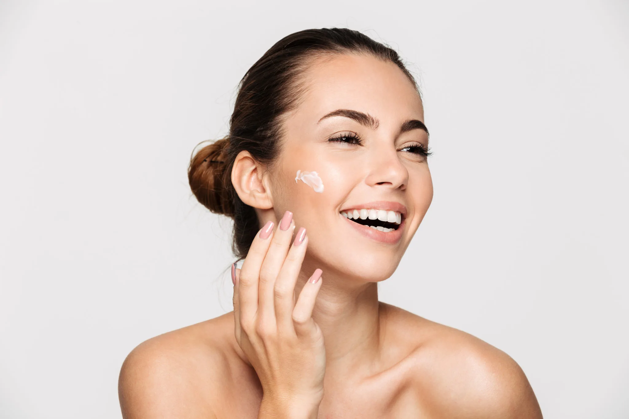 a woman smiling with a cream on her face | | Allure Dermatology | Edinburg, TX